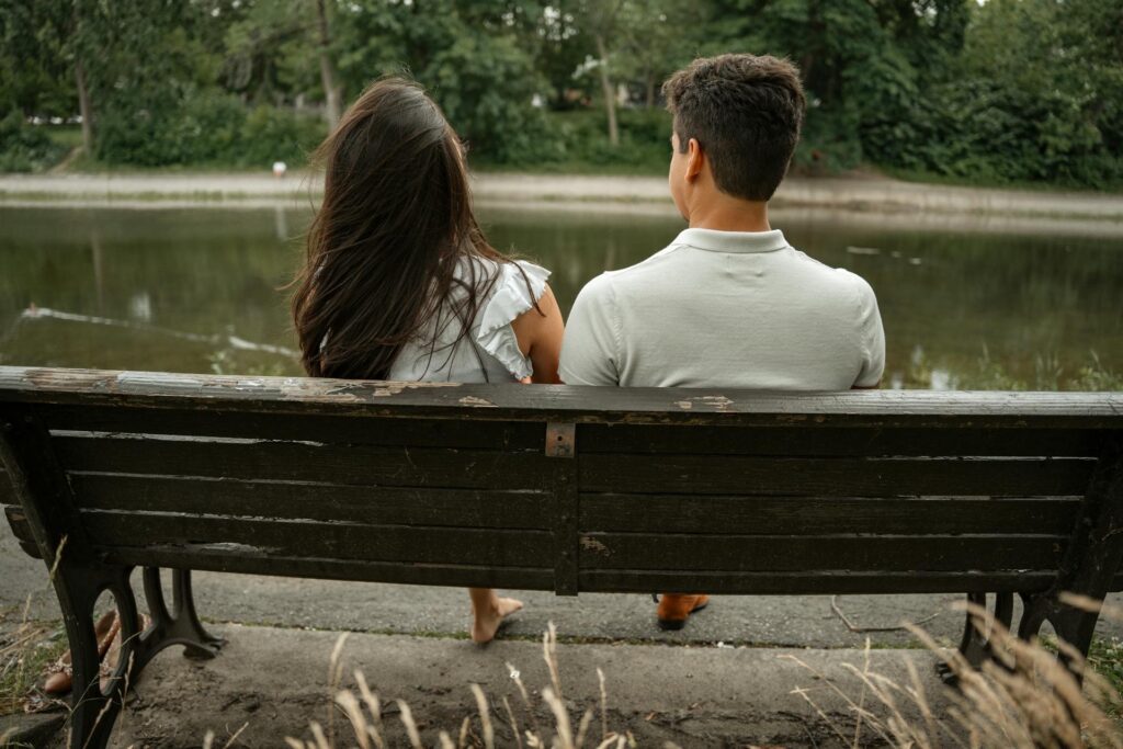 Pareja sentada en un banco junto al lago, simbolizando el equilibrio entre el tiempo juntos y el espacio personal en una relación.