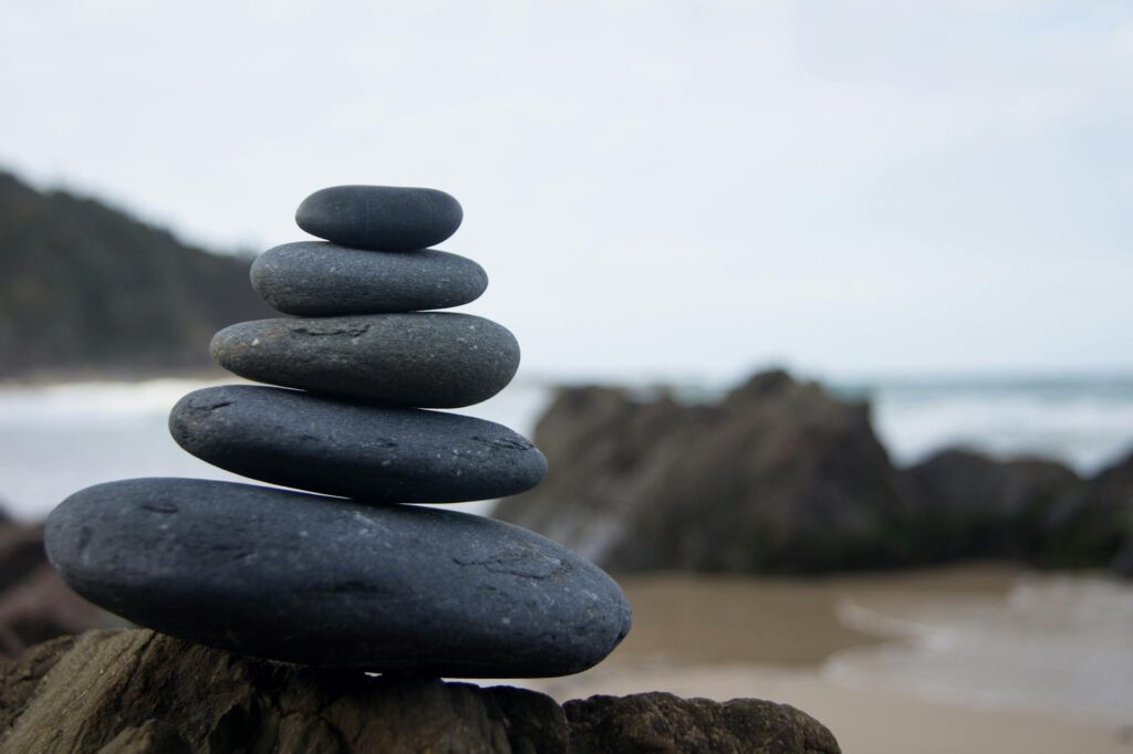 Piedras apiladas en equilibrio sobre la playa, representando la armonía y el balance en una relación de pareja.