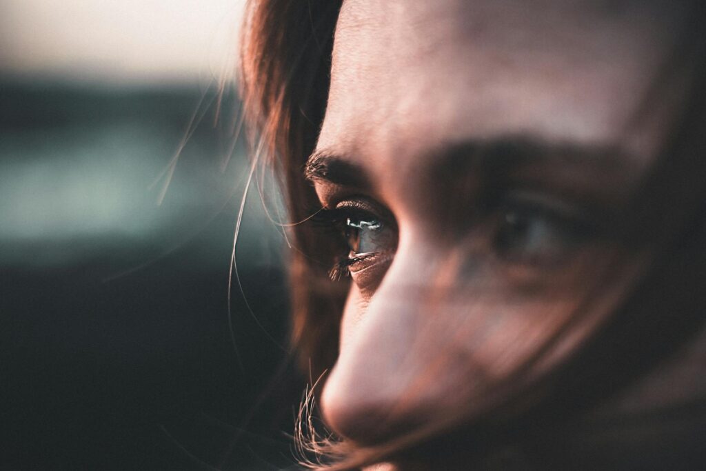 Primer plano de una mujer reflexionando, representando la liberación de la carga emocional.