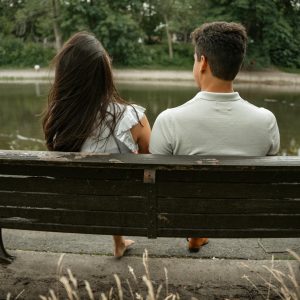 Pareja sentada en un banco junto al lago, simbolizando el equilibrio entre el tiempo juntos y el espacio personal en una relación.