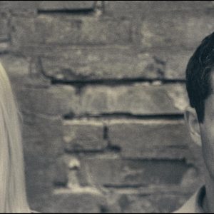 Pareja distanciada frente a una pared, simbolizando una pausa en la relación y la reflexión personal.